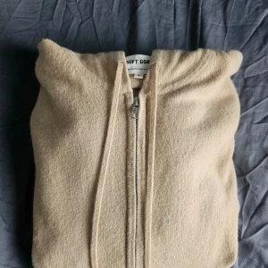 Beige kashmirhoodie från Soft Goat - Mjuk och lyxig beige hoodie från Soft Goat i 100% kashmir. Skick: 10/10. Nypris ligger runt 3000. Storlek S och sitter som S
