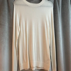 Ljusbeige långärmad stickad tröja - En stilren och enkel ljusbeige stickad tröja med rund halsringning och långa ärmar. Den är aldrig använd!