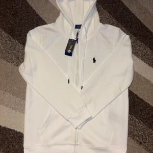 Ralph Lauren - Vit Kofta - Säljer nu min vita Ralph Lauren kofta helt ny med prislappen. Den är Storlek L med du som har M skulle det passa till. Vid frågor skriv bara och vid snabb affär kan pris diskuteras.