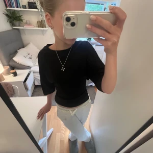 Svart topp från Nelly  - Svart trendy topp från Nelly med knutte i ryggen. Tröjan är i storlek XXS men skulle tippa på att den även passar folk som normalt har XS❤️