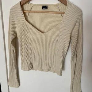 Ljusgul ribbad tröja från Gina Tricot - Superfin ljusgul ribbad tröja från Gina Tricot med v-ringad hals och lång ärm. Tröjan är i mjukt material och är använd fåtal gånger💛