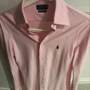 Ralph lauren skjorta  - Säljer nu denna rosa raffe skjortan för att den är för liten, väldigt stilren och perfekt för dagar där man vill vara lite extra fin