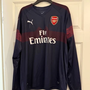 Arsenal Bortaställ 2018/19  - Långärmad arsenal bortaställ tröja i XL, från 2018/19 säsongen. Tröjan är i princip i nytt skick förutom att den saknar prislapp. Notera att tröjan är i autentiskt skick.