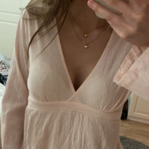 Ljusrosa omlottopp från Gina Tricot - Supersöt ljusrosa omlottopp från Gina Tricot med rosett därbak. Möjligtvis en mini fläck på framsidan men inget man ser💕