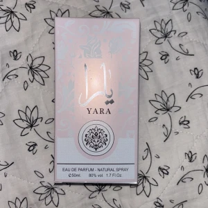 Yara Eau de Parfum 50ml - Yara Eau de Parfum från Ard Al Zaafaran, 50ml. Snygg ljusrosa kartong med silverdetaljer och orientaliskt mönster. Parfymen är en naturlig spray med 80% volym alkohol. Perfekt för dig som gillar eleganta och feminina dofter.