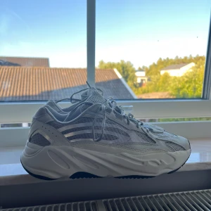 Adidas Yeezy 700 - Säljer ett par Adidas Yeezy 700 V2 Static sneakers i ljusgrått och vitt. Skorna har chunky sula, mesh och skinnpaneler samt de klassiska tre ränderna på sidan. Perfekta för dig som gillar streetwear. Pris kan absolut  diskuteras vid snabbt köp. Knappt använda.