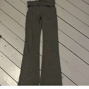 Grå bootcut mjukisbyxor - Mysiga grå mjukisbyxor med bootcut-ben och bred, vikt midja. Perfekta för chill dagar eller när du vill vara bekväm men ändå ha lite stil. Mjukt material som känns skönt mot huden.