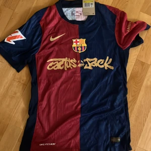 FC Barcelona Lamine Yamal Nike tröja - Säljer en officiell FC Barcelona matchtröja från Nike med Lamine Yamal 19 på ryggen. Tröjan är kortärmad och har klassiska blå och röda paneler, guldfärgade detaljer och klubbmärke på bröstet. Materialet är lätt och andas, perfekt för fotboll eller att bära som supporter.