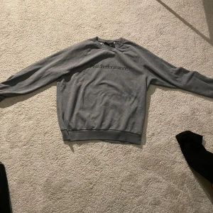 Grå Peak Performance tröja - Säljer en grå sweatshirt från Peak Performance med svart logga på bröstet. Tröjan har rund hals, långa ärmar och ribbade muddar vid ärmslut och nederkant. Perfekt för chill dagar eller när du vill ha en clean och enkel stil. Använd ett få par gånger 