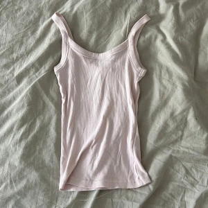 Ljusrosa ribbad linnetopp - Supersöt ljusrosa linnetopp med ribbad struktur och breda axelband. Perfekt att styla med jeans eller shorts för en chill look. (XXS MEN PASSAR XS, väldigt stretchigt🌟)