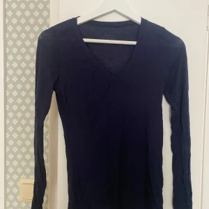 Mörkblå v-ringad tröja Intimissimi - Snygg mörkblå långärmad tröja från Intimissimi i ultralätt material med kashmir. V-ringad modell som sitter slim och är perfekt för lager-på-lager. Enkel och stilren design som funkar till många olika looks. Inte använt så mycket så den är fortfarande i snyggt skick 