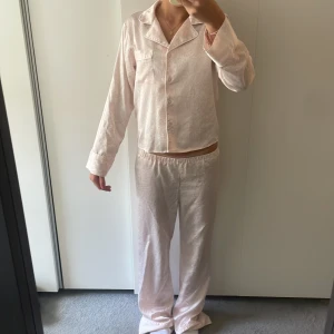 Ljusrosa pyjamaset från Gina Tricot - Säljer ett ljusrosa pyjamasset från Gina Tricot med diskret leopardmönster. Byxorna är raka i modellen, har resår i midjan. Perfekta för mysiga hemmakvällar.