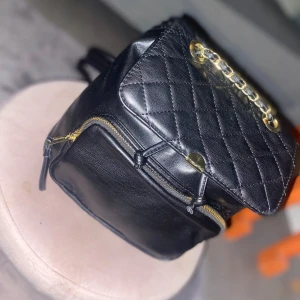 Svart quiltad ryggsäck Don Donna - Snygg svart ryggsäck från Don Donna i skinn ( inte äkta) helt oandvänd perfekt till skolstarten jag mycket plats och små fickor där man kan lägga plånböcker skriv för mer bilder och frågor köpt för 999