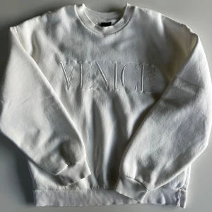 Vit sweatshirt  - Vit sweatshirt från Gina Tricot med broderad text 'VENICE' framtill. Klassisk rund halsringning, ribbade muddar och avslappnad passform. Perfekt till jeans för en clean och stilren look🤍