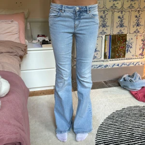 Ljusblå bootcut jeans - Säljer ett par ljusblå jeans med bootcut-modell. Jeansen har klassisk femficksdesign, normal passform och är tillverkade i mjukt denimtyg. Perfekta för dig som gillar en retro vibe och vill ha ett par snygga jeans med lite utsvängda ben.