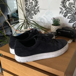 Svarta mockasneakers från Vagabond - Stilrena svarta sneakers från Vagabond i mocka med klassisk rund tå och vit platt sula. Skorna har snörning och en enkel, clean design som passar till det mesta. Perfekta för dig som gillar en tidlös och avslappnad look.