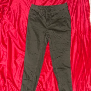 Gröna jeans med fickor - Säljer ett par gröna byxor med klassisk femficksdesign och dragkedjegylf. Perfekta till sneakers eller boots.