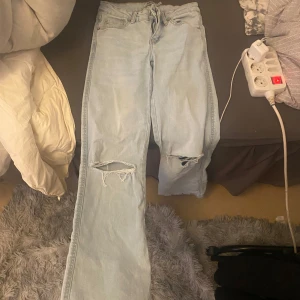 Ljusblå slitna jeans med raka ben - Säljer ett par jätte snygga ljus blåa jeans med håll på knäna och snygga fickor på baksidan,  sitter jätte fint på .Dem är i storlek XXS men passar XS dem är short lenght men är inte så jätte korta
