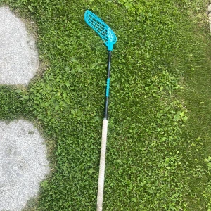 Zone Floorball Innebandyklubba - Snygg innebandyklubba med blått blad och svart skaft, perfekt för dig som vill ta ditt spel till nästa nivå! Greppet är fräscht och designen sticker ut på planen. Passar både träning och match för ungdomar och unga vuxna som älskar fart och action.