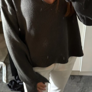Mörkgrå stickad tröja med krage - Säljer en mörkgrå stickad tröja med bred krage och v-ringad hals. Tröjan har långa ärmar med ribbade muddar och en loose passform. Jätte snygg men kommer inte till användning längre💞