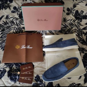 Blå mockaloafers från Loro Piana - Snygga loafers från Loro Piana i blå mocka med vit sula. Modellen heter Summer Walk och har en stilren, klassisk design med rund tå och diskreta sömmar. Perfekta för dig som gillar exklusiva och bekväma skor med premiumkänsla.