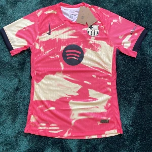 Barcelona x Nike fotbollströja - Snygg Barcelona fotbollströja från Nike med coolt abstrakt mönster i rosa och beige. Kortärmad modell med svart Nike-logga och FCB-emblem på bröstet. Spotify-logga på framsidan och UNHCR-tryck på ryggen. Tillverkad i lätt, ventilerande polyester. Tröjan är player version vilket gör att den sitter lite bättre och det är lättare att andas i den.