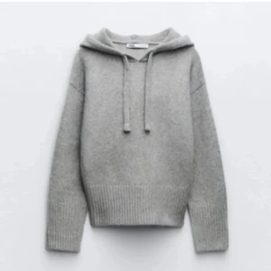 Grå hoodie med ribbade detaljer - Säljer en stilren grå hoodie med ribbade muddar och nederkant. Tröjan har en bekväm passform och en klassisk huva med dragsko. Perfekt för kyliga dagar.