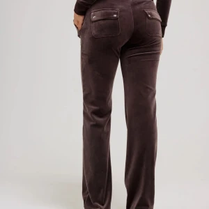 Bruna Juicy Couture byxor - Snygga bruna mjukisbyxor från Juicy Couture i mjuk velour med bred resårmidja och snörning framtill. Byxorna har raka ben, stora fickor både fram och bak med silverfärgade knappar. Perfekta för chill eller streetwear.