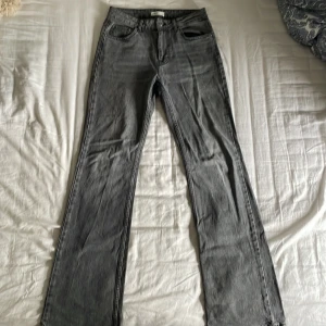 Grå bootcut jeans från Gina Tricot - Säljer ett par grå jeans från Gina Tricot i bootcut-modell. Jeansen är lite slitna längst ned då de var lite för långa och stora på mig (är 168 cm lång). Annars är de i väl skick. Står att de är storlek 36 men de är mycket större i verkligheten så skulle säga 38 i storlek. Köpare står för frakt 