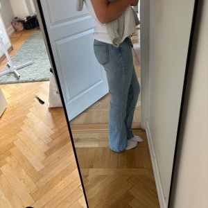 Ljusblå bootcut jeans - Säljer ett par ljusblå jeans med bootcut passform . Jeansen har låg midja och är tillverkade i mjukt denimtyg.