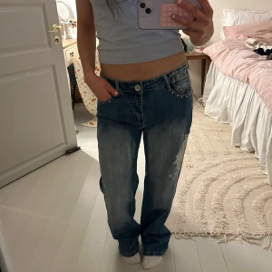 Blå jeans med broderade detaljer💘 - Snygga blå jeans med unika broderade detaljer på bakfickan och ett coolt mönster på benet. Säljer pg inte helt min stil🩵kom privat för mått!