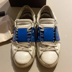 Valentino Garavani sneakers med blå detalj - Ett par 110% äkta valentino opens med snygg färg, onlinekvitto, serienummer, 2 dustbags å lite mer vltn kort!!!!! Säljs billigare pga av hyfsat dåligt skick å en liten skada ( kom gärna med prisvärda byten!)🙏🥂