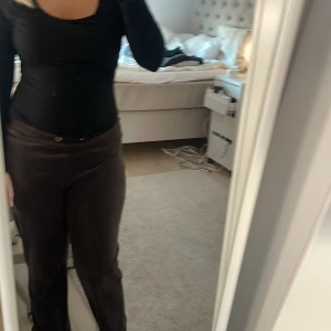 Bruna byxor från Gina Tricot - Snygga bruna byxor från Gina Tricot i storlek S. Byxorna har en klassisk design med en rak passform och är tillverkade i ett mjukt material. Perfekta för en stilren look.