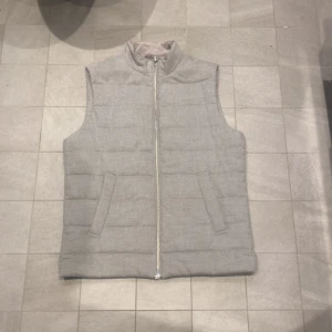 Grå Quiltad Väst - Asfet grå quiltad väst från Dressmann, säljer då den är lite för stor för mig. Passar 180-190 långa ungefär. Kan passa de som i vanliga fall har M. 10/10 skick använd 3 gånger. Vid fler frågor eller funderingar är det bara skicka iväg ett meddelande!