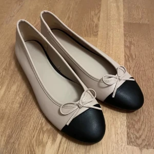  Ballerinaskor med rosett - Snygga ballerinaskor i beige med svart tå och en söt rosett framtill. Perfekta för en stilren look. Säljer eftersom de va för stora, (inte min bild)💞