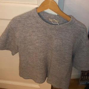 Grå stickad tröja från Gina Tricot💘💘 - Mysig grå stickad tröja från Gina Tricot i premiumkvalitet. Tröjan har en rund halsringning och korta ärmar, perfekt för lager-på-lager eller som den är. En stilren och bekväm baströja för alla tillfällen.