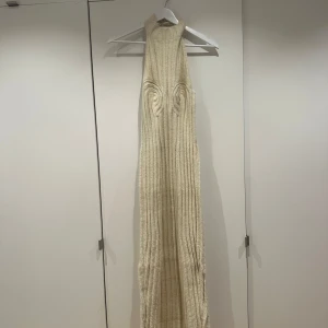 Cervinia Dress från ADOORE - vit stickad  långklänning från ADOORE med halterneck-design. Inköpt på sample sale men passade tyvärr ej.