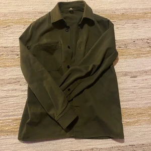 Arket overshirt - Snygg olivgrön overshirt med knappar och två bröstfickor. Skick:7/10  och inga defekter. Storlek är 175 cm. Skriv vid minsta funderingar!  