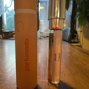 Parfym Goudh från Fugazzi - Elegant parfymflaska från Fugazzi med doften Goudh. Flaskan är smal och genomskinlig med en silverfärgad kork. Förpackningen är i en stilren orange tub från Parfumado. Perfekt för den som söker en unik och sofistikerad doft.8ml - 1 sprut. 