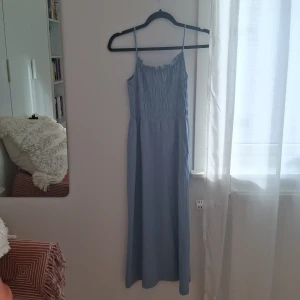 Ljusblå långklänning från H&M - Ljusblå sommarklänning från H&M i väldigt bra skick, använd 1 gång. Man kan juster axel banden, det är dam XS, jag är 170 cm 