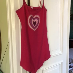 Rosa linnetopp från Miss Selfridge - Säljer en söt rosa linnetopp från Miss Selfridge med ett hjärtmönster i flera nyanser på framsidan. Toppen har smala axelband och är perfekt för en avslappnad stil. Tillverkad i bomull och elastan för en bekväm passform.