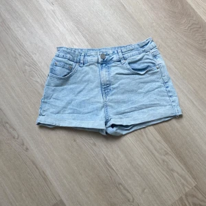 Ljusblå jeansshorts från FB Sister - Snygga ljusblå jeansshorts från FB Sister med klassisk femficksdesign. Perfekta för varma dagar och enkla att matcha med allt. De har normal passform och är tillverkade i mjukt denimtyg för en avslappnad vibe. High waist. 
