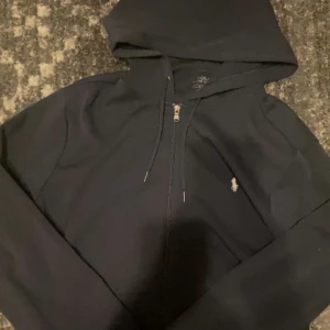 Mörkblå hoodie från Polo Ralph Lauren - Snygg mörkblå hoodie från Polo Ralph Lauren med dragkedja och huva.. Perfekt för chill dagar och enkel att matcha med jeans eller joggers. Jättebra kvalité och är som ny