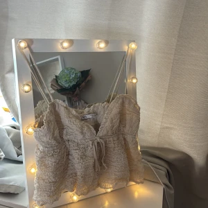 Beige smockad linnetopp från Zara - Supersöt beige linnetopp från Zara med smockad struktur och tunna axelband. V-ringad☺️