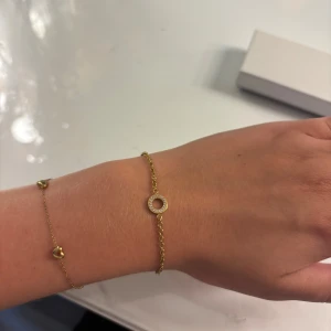 Guldigt armband med cirkel och stenar - Snyggt och tunt armband i guldton med en rund cirkel i mitten, dekorerad med små glittrande stenar❣️