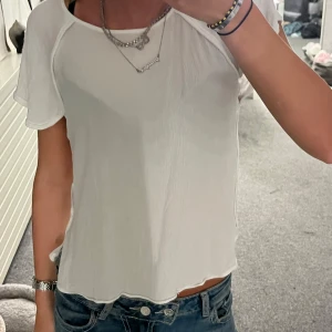 Vit blus  - Säljer en söt vit blus från Zara med korta volangärmar och lätt vågig kant nertill. Tunt och luftigt material som känns perfekt för varmare dagar. Enkel och stilren design som är lätt att matcha med jeans eller kjol.