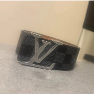 Louis Vuitton belte - En jätte bra och fin grå och svart LV belte med en silver lv logo.