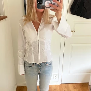 Vit figursydd topp - Säljer denna figursydda topp med långa ärmar. 🤍aldrig använd, prislapp kvar!