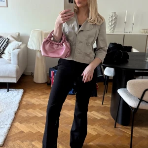 Beige kort kappa med stora knappar - Snygg beige kappa med kort passform och stora dekorativa knappar framtill. Jackan har trekvartsärmar och bred krage, vilket ger en trendig och stilren look.