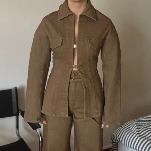 Brun jeans-overshirt från Avora - Säljer en brun figursydd overshirt från Avora i jeansmaterial. Skjortan har långa ärmar, markerad midja. 